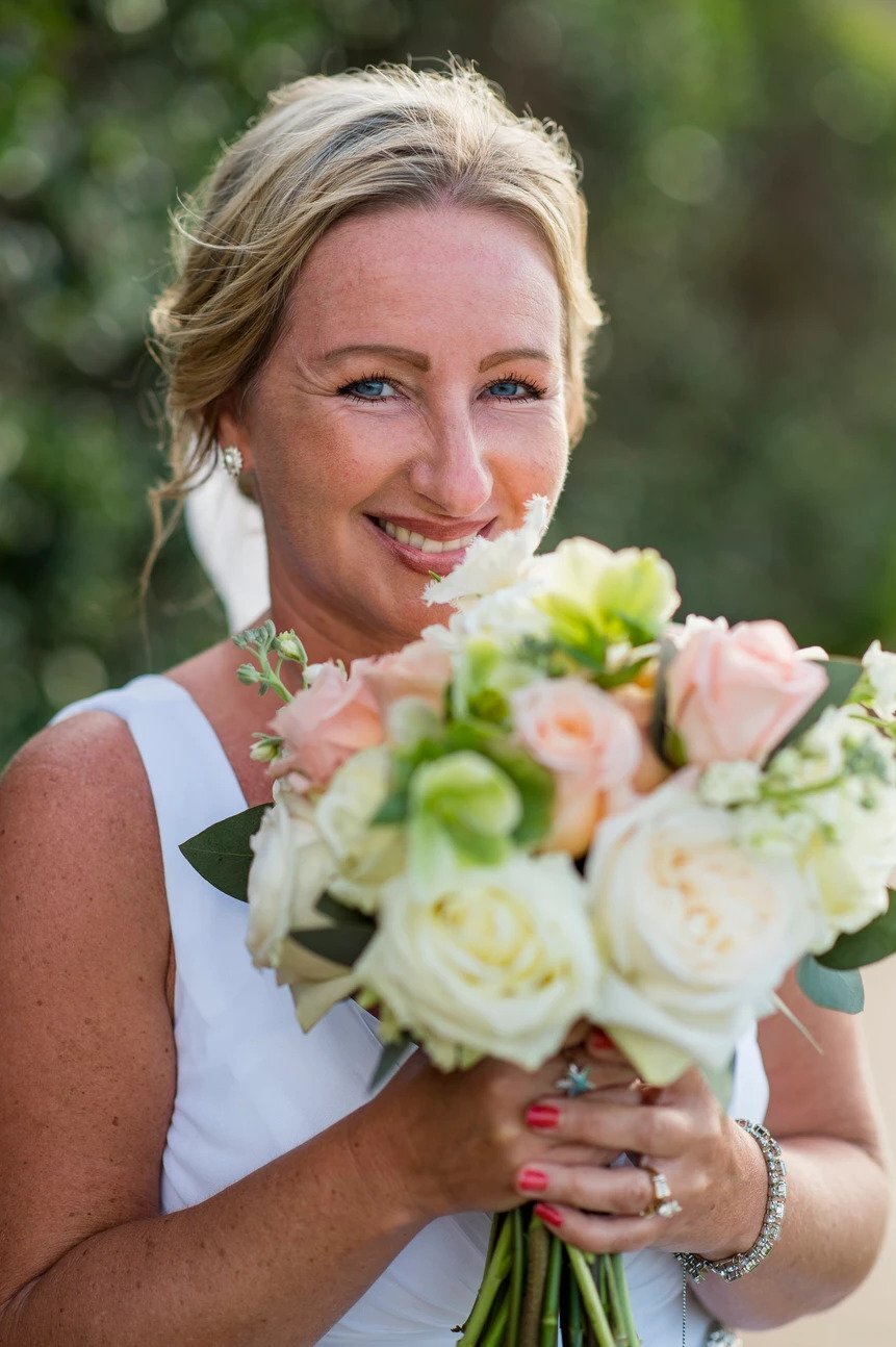 A Maui bride smiling holding her bouquet
