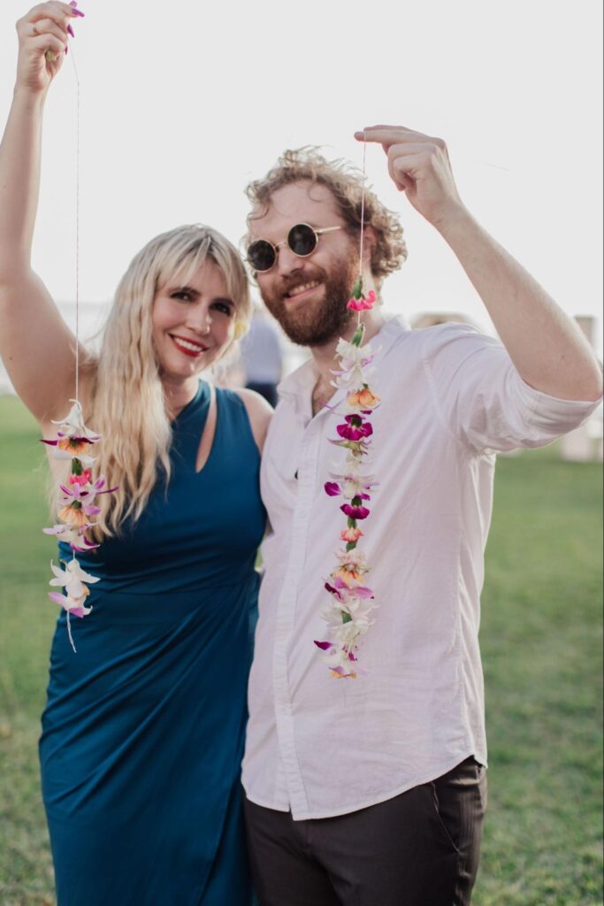 a couple holds up their leis at a Maui wedding
