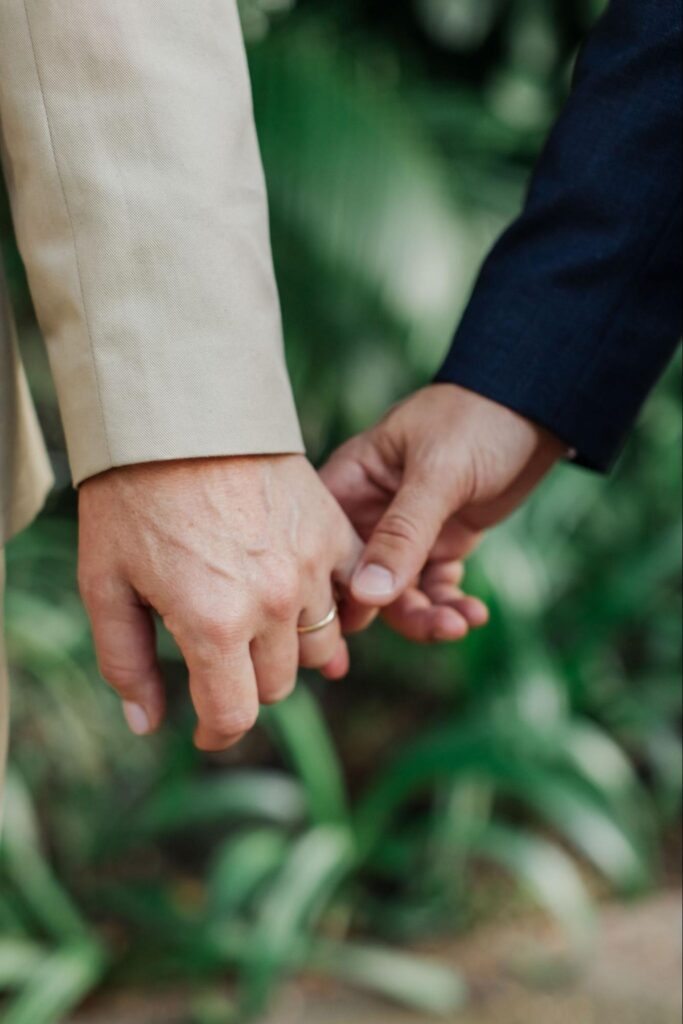 close up of two grooms holding hands