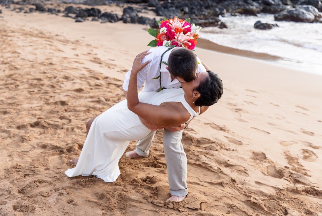 newlyweds share their first kiss on the beach in Maui, Hawaii
