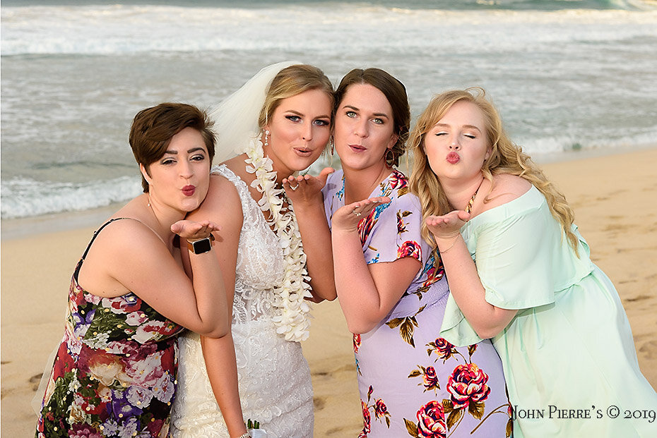 bride and bridesmaids blow kisses to the camera on Maui beach