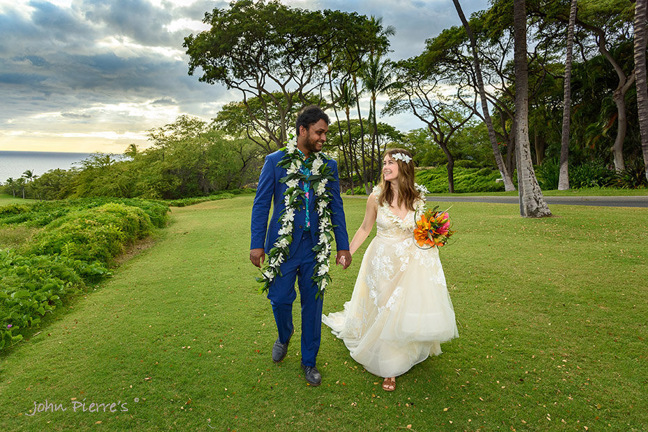 bride and groom hold hands walking on hotel grounds in Maui