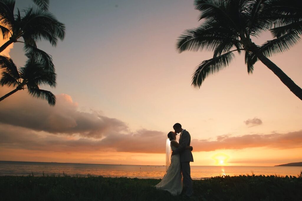 couple kisses at sunset on the beach in Maui
