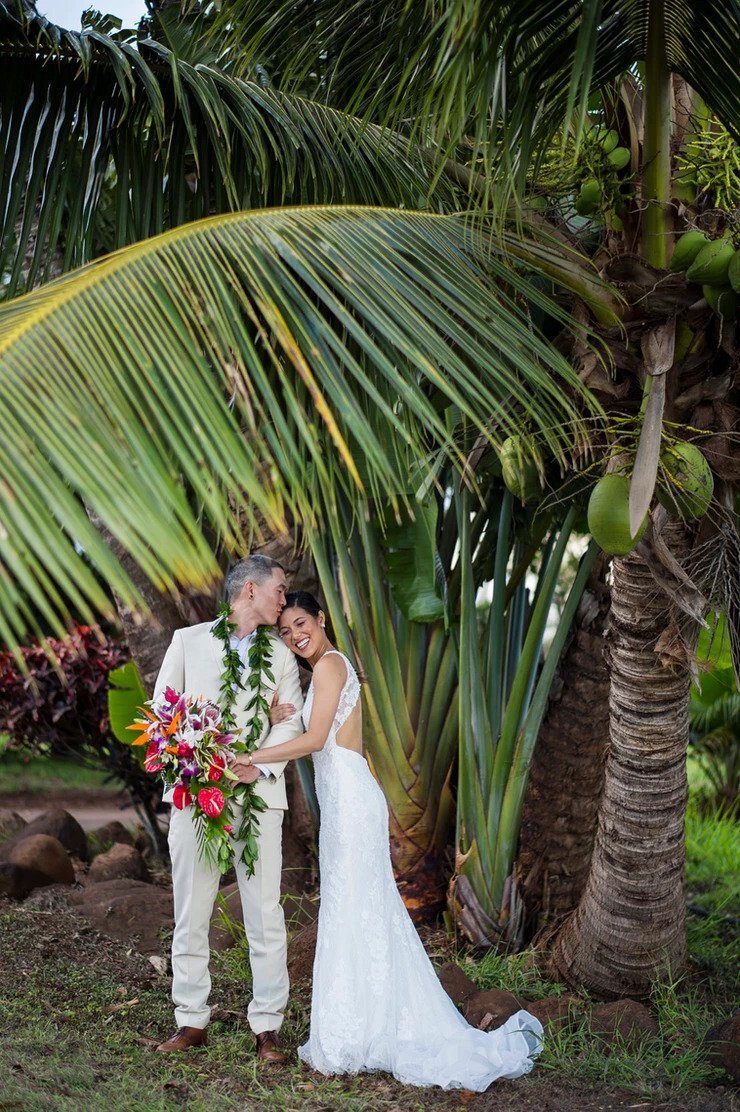 couple embracing under a tree at their vow renewal in Maui Hawaii